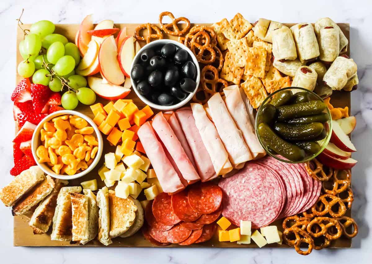 kid-friendly charcuterie board filled with meat, cheese, fruit and snacks